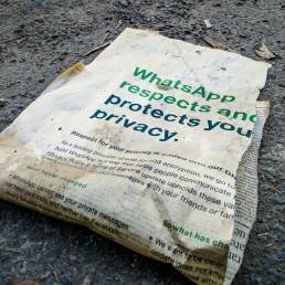 a newspaper laying on the ground with whatsapp on it