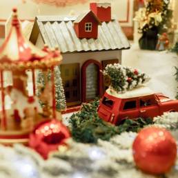 a christmas scene with a toy car and a house